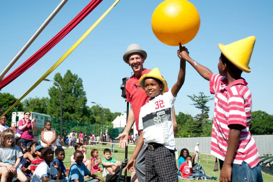 2 boys spinning a yellow ball on their finger