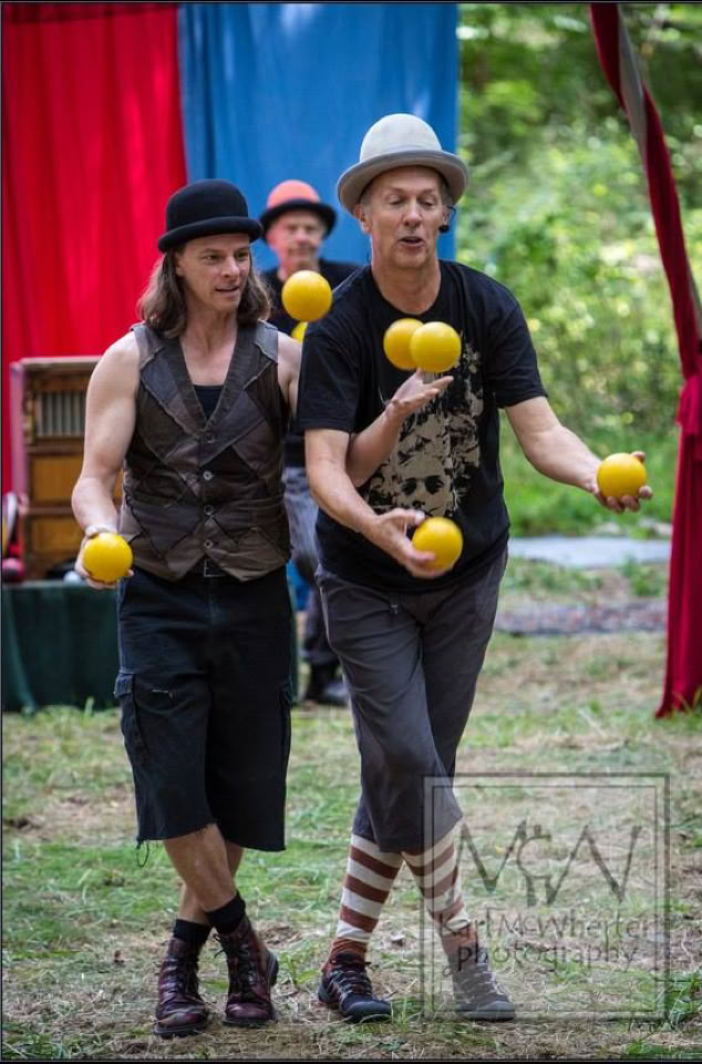 2 jugglers with 6 yellow balls outdoor festival